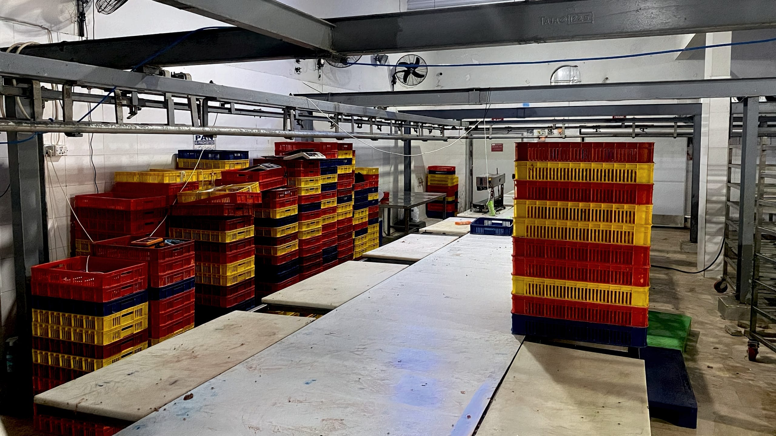 Cutting tables and stacked crates in the processing hall